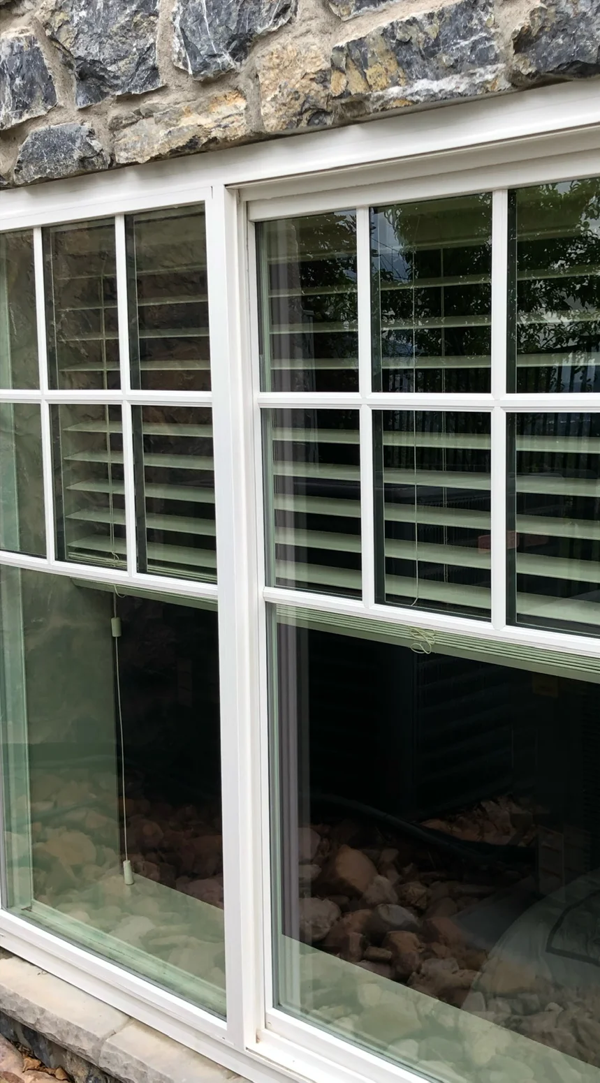 White-framed windows in a stone wall after cleaning