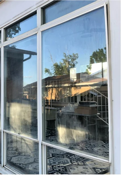Sunroom window glass viewed from outside before cleaning