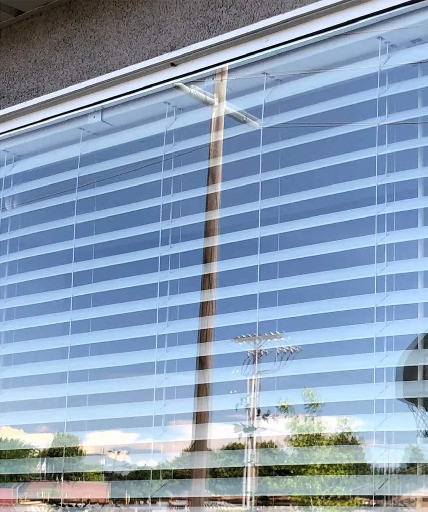 Window glass with white blinds behind it after cleaning