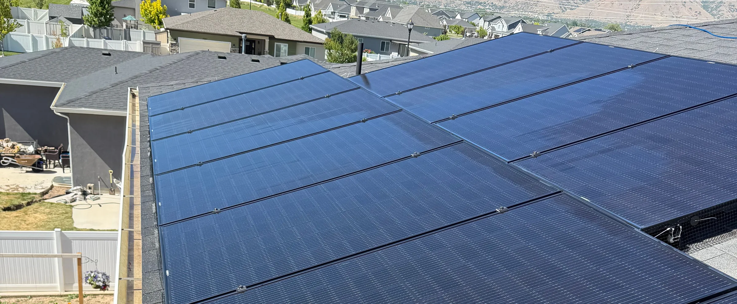 Rooftop solar array, panels filling the frame, with the Wasatch mountains behind