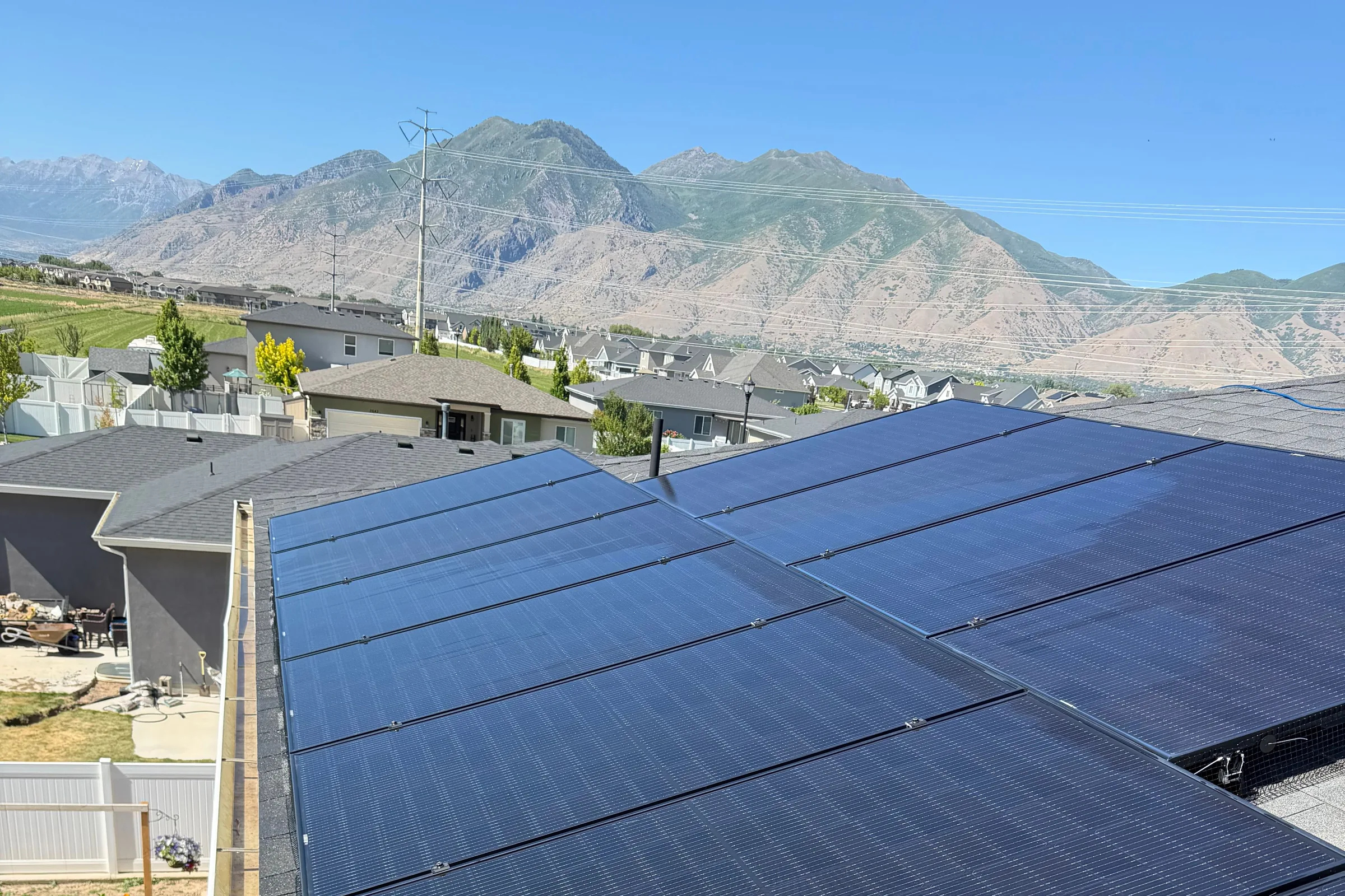 Rooftop solar array, panels filling the frame, with the Wasatch mountains behind