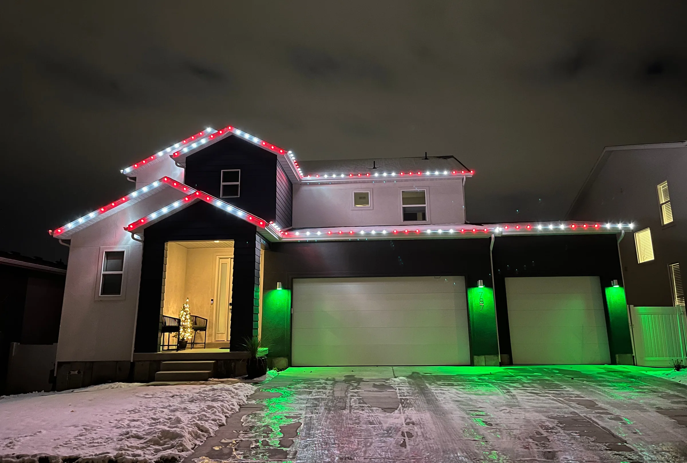 Red and white rooflines with green light under the eaves