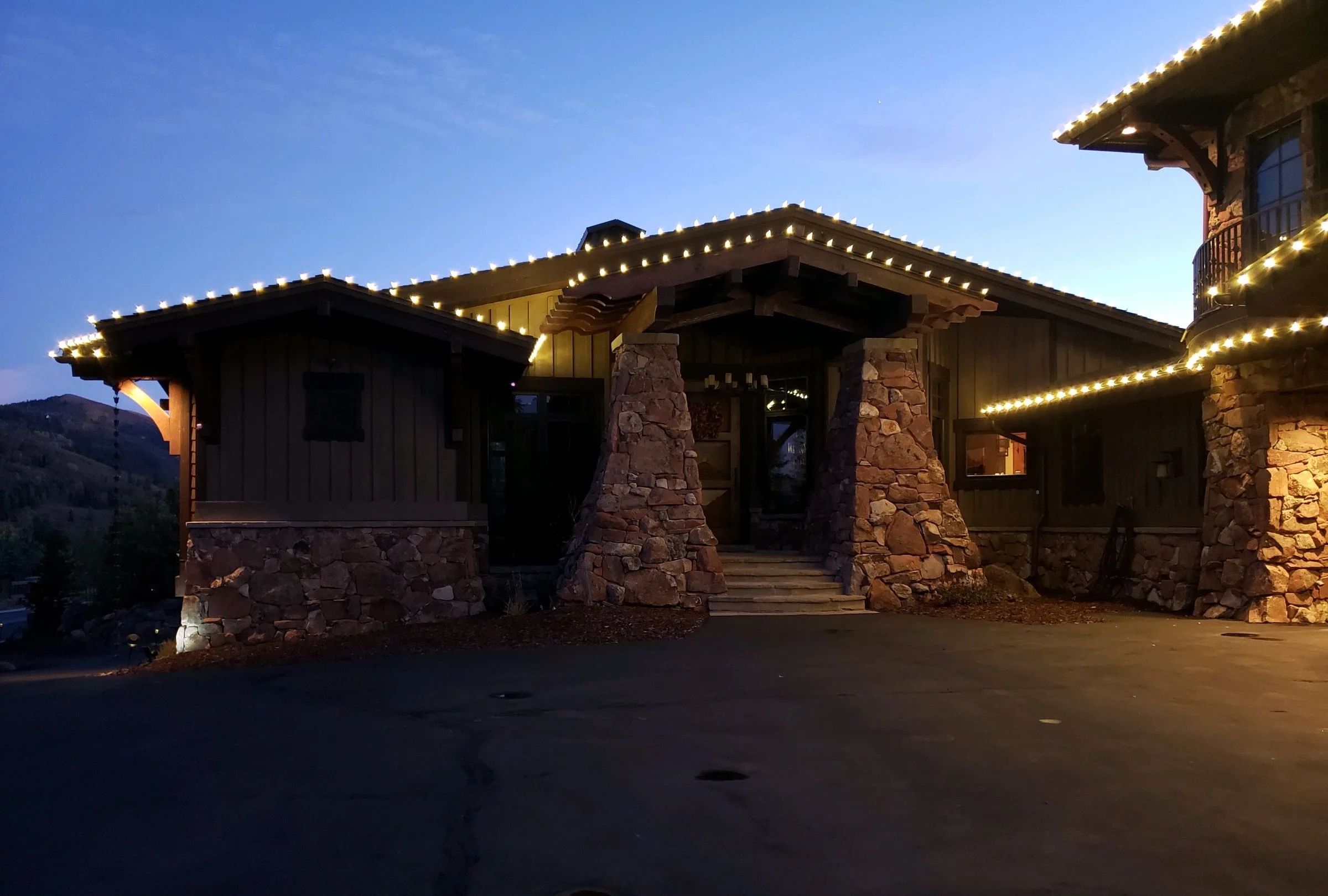Lodge-style home with stone pillars and warm rooflines