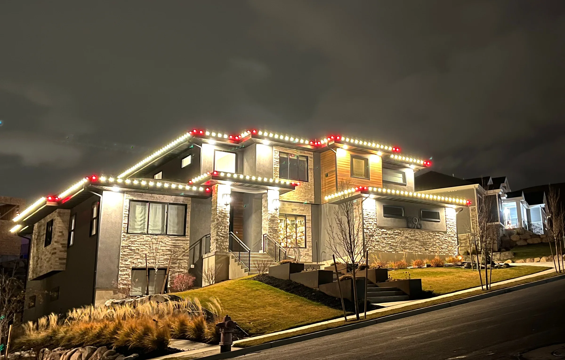 Modern hillside home in warm white with red accents