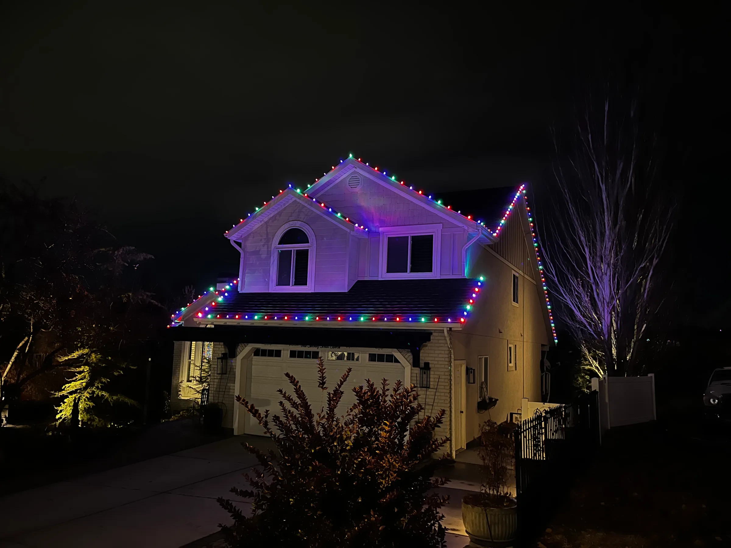 Two-story home with multicolour roofline lights over the garage