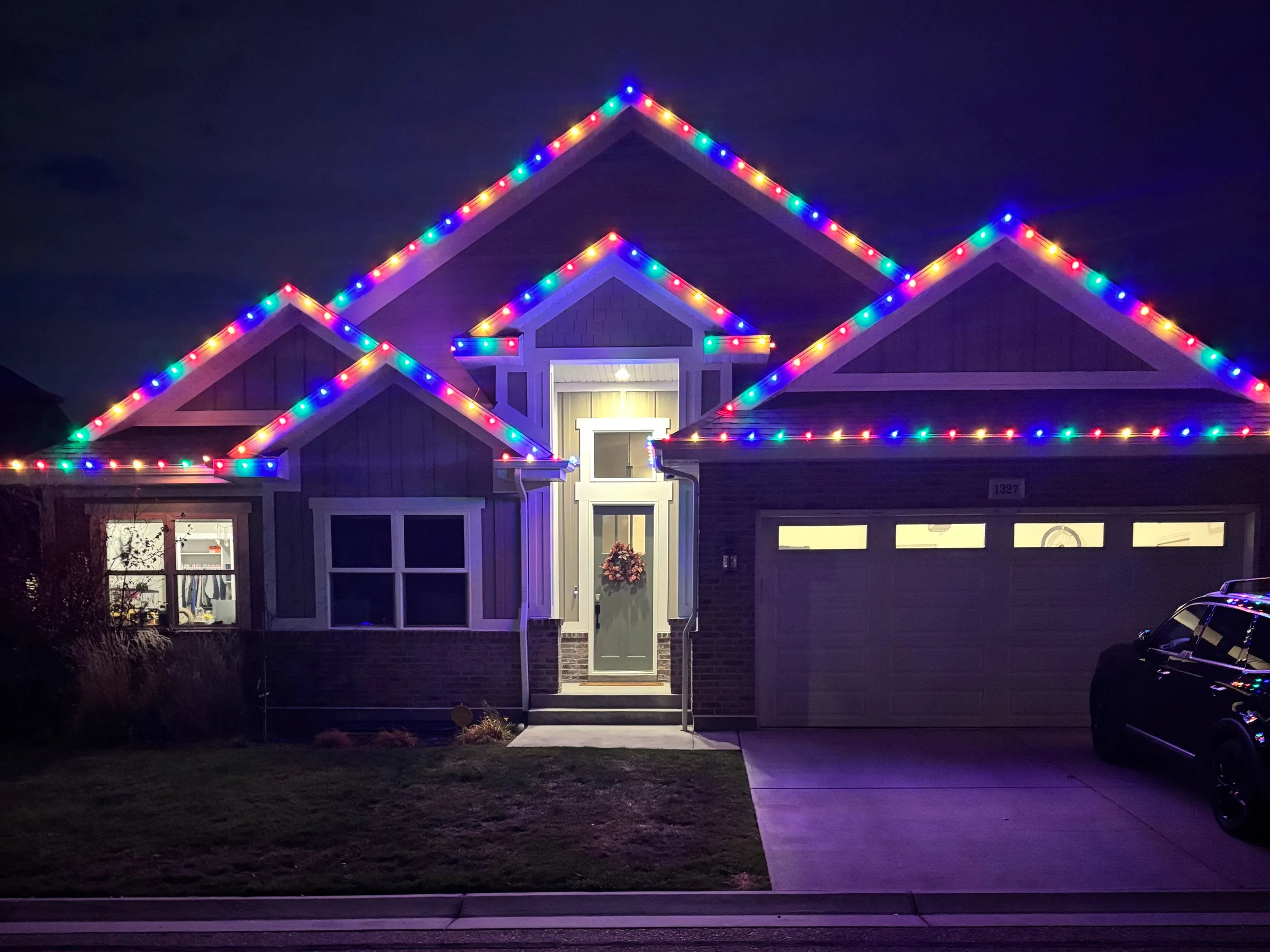 Single-story home with multicolour gables at night