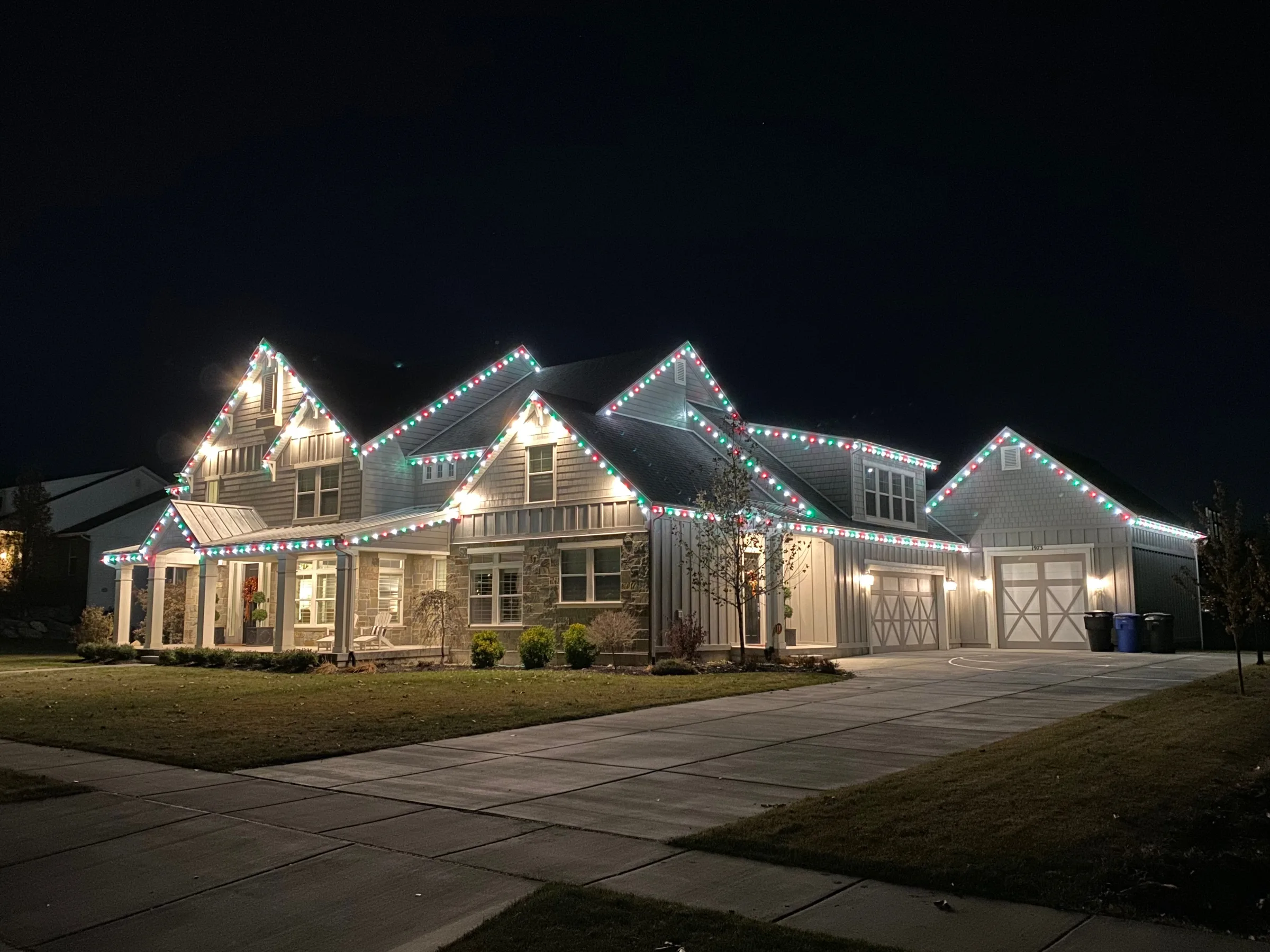 Large home with red, green and white lights on every gable