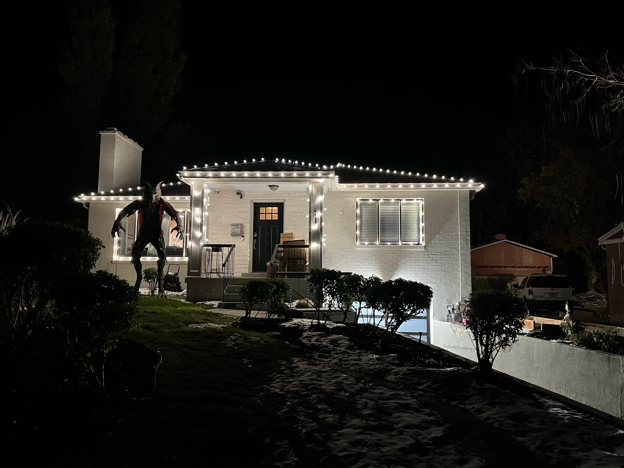 Two-story white home outlined at night