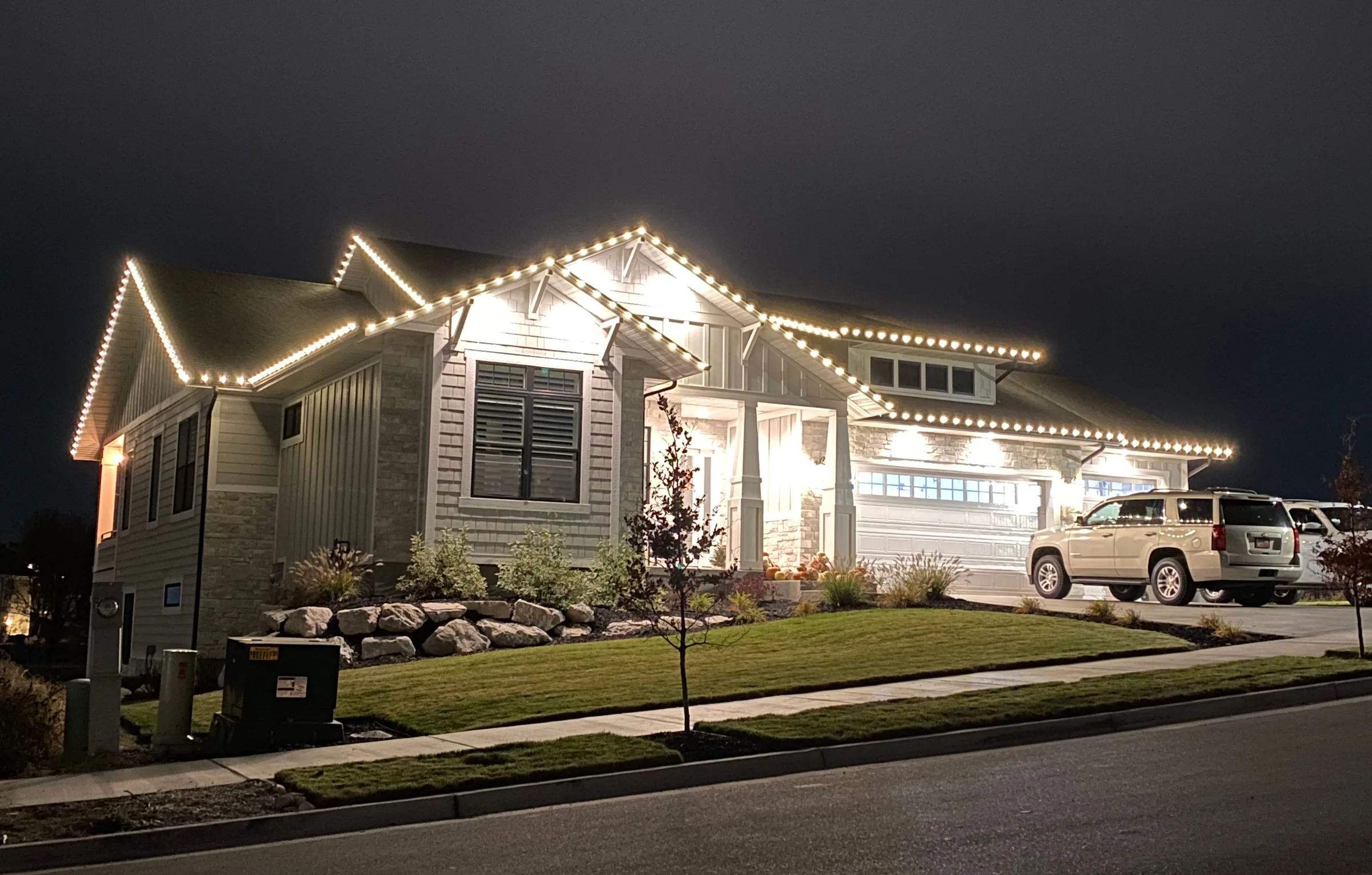 White craftsman home with every gable lit